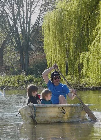 A family enjoying a rowing boat trip on the river at Upper Court